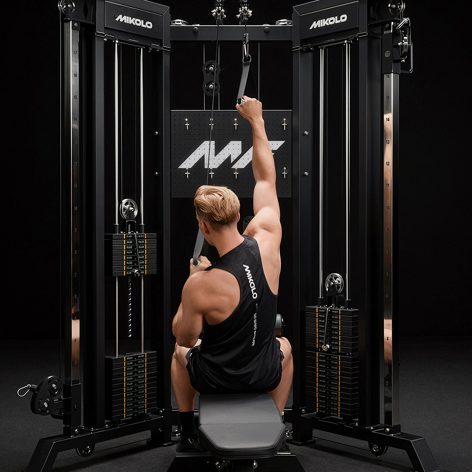 A user performing single-arm lat pulldowns on the Mikolo FALCON 2.0 Functional Trainer with dual weight stacks