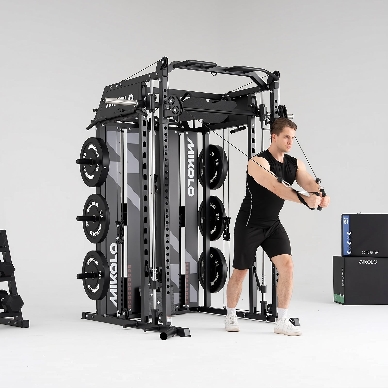 Man performing a cable exercise on a black MIKOLO Smith machine and functional trainer with weight plates loaded
