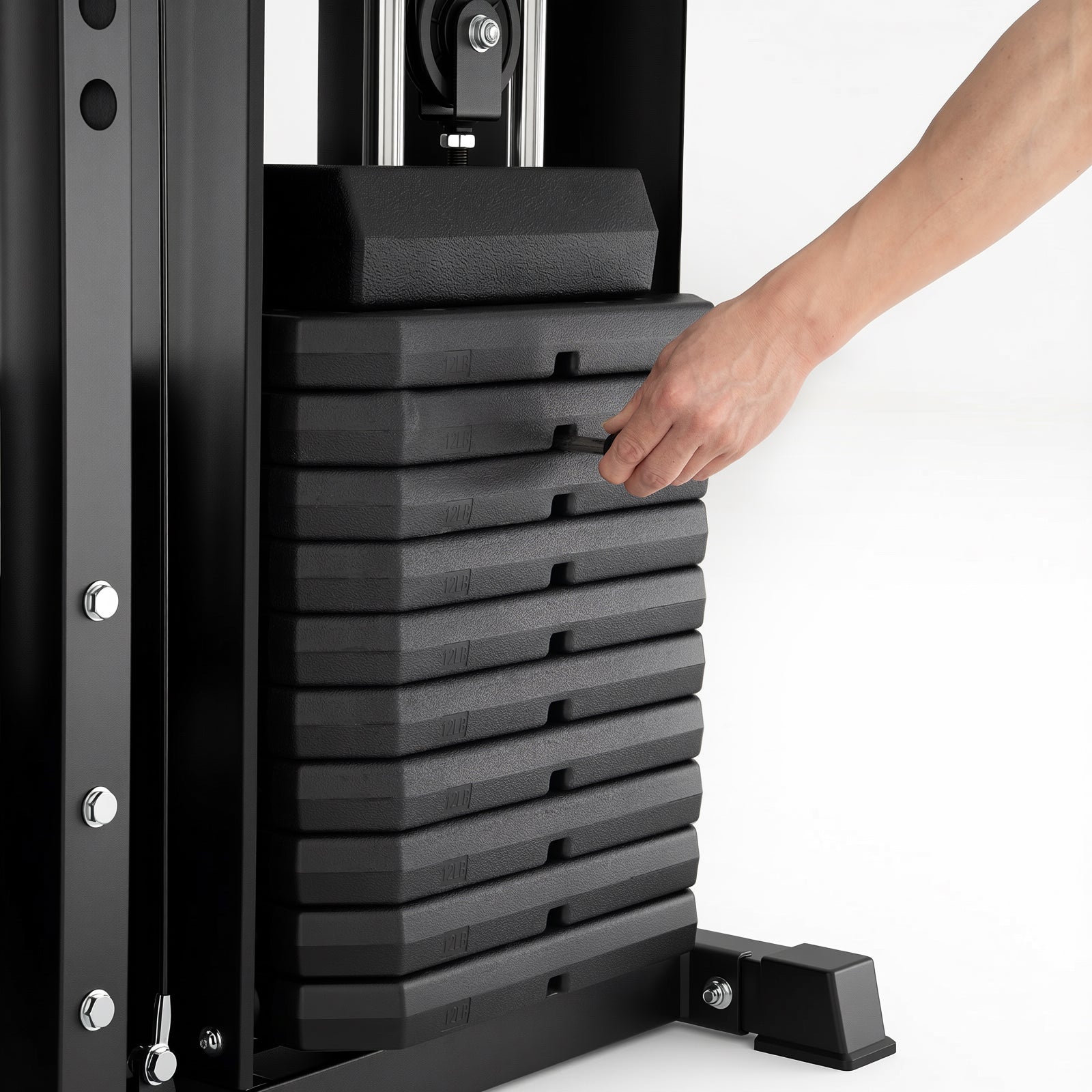 A hand adjusts the selector pin on a vertical stack of black weight plates on a gym machine