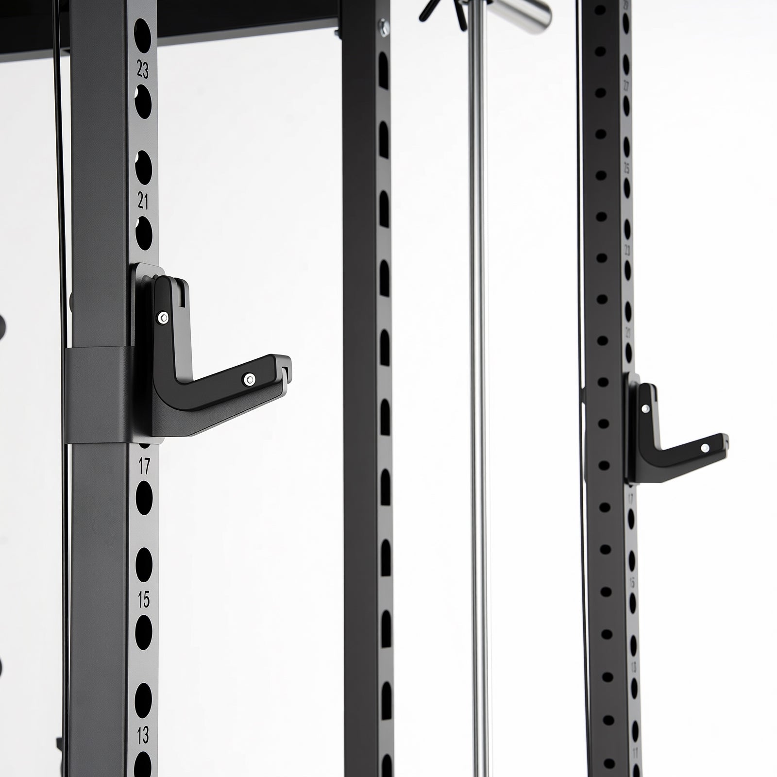 Close-up of black Smith machine uprights with numbered adjustment holes and attached J-hooks for barbell support