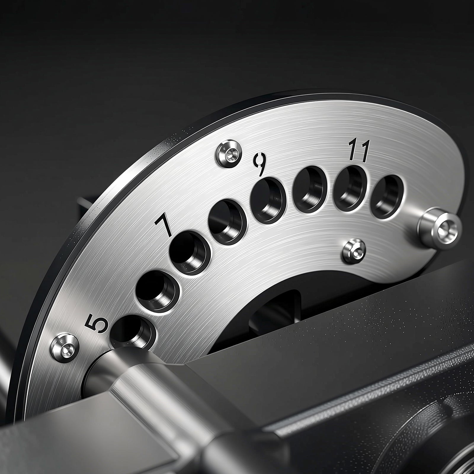 Close-up of a brushed silver metal dial with numbered holes from 5 to 11 for selecting resistance levels on gym equipment