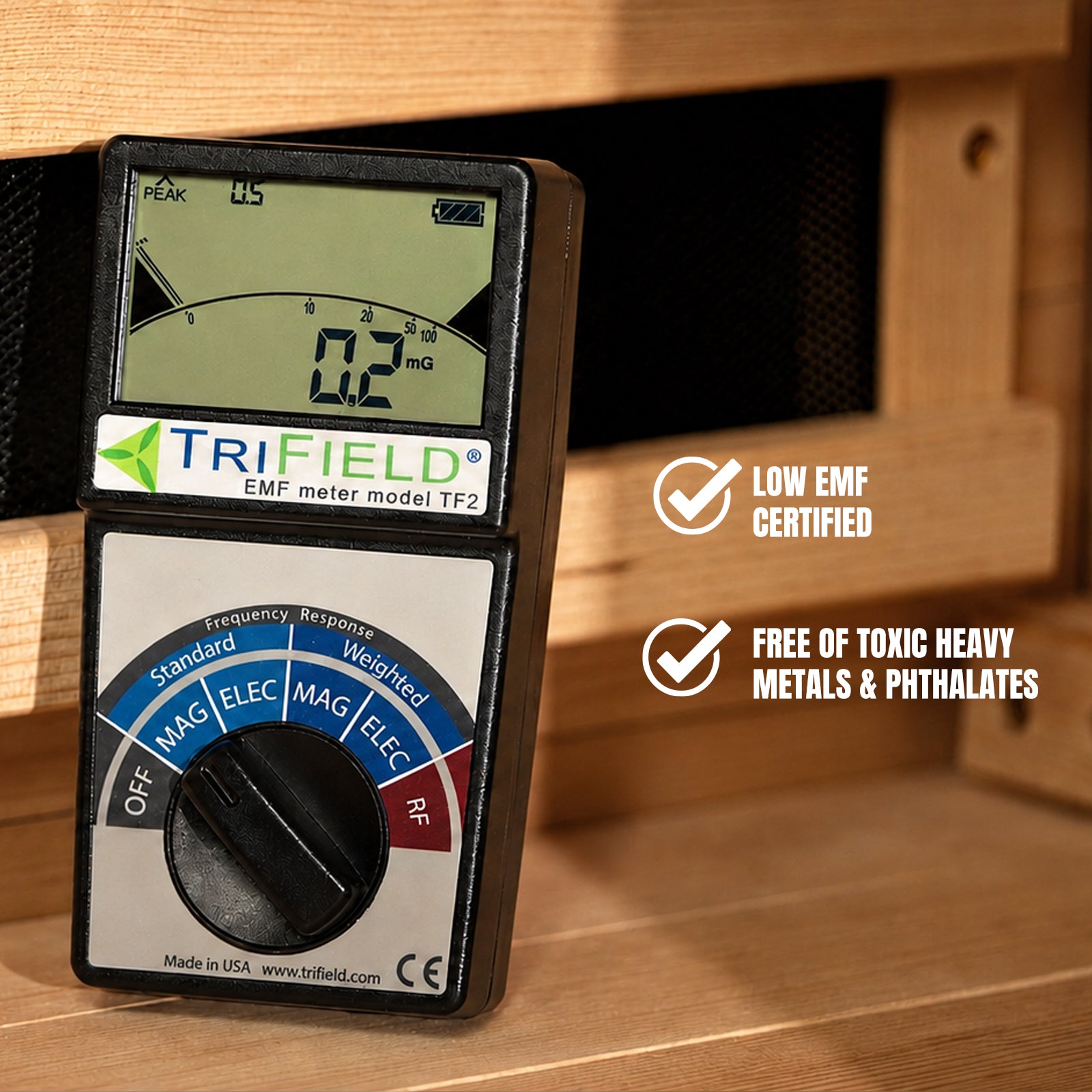 Trifield TF2 EMF meter reading 0.2 mG on wood, labeled Low EMF Certified and Free of Toxic Heavy Metals & Phthalates